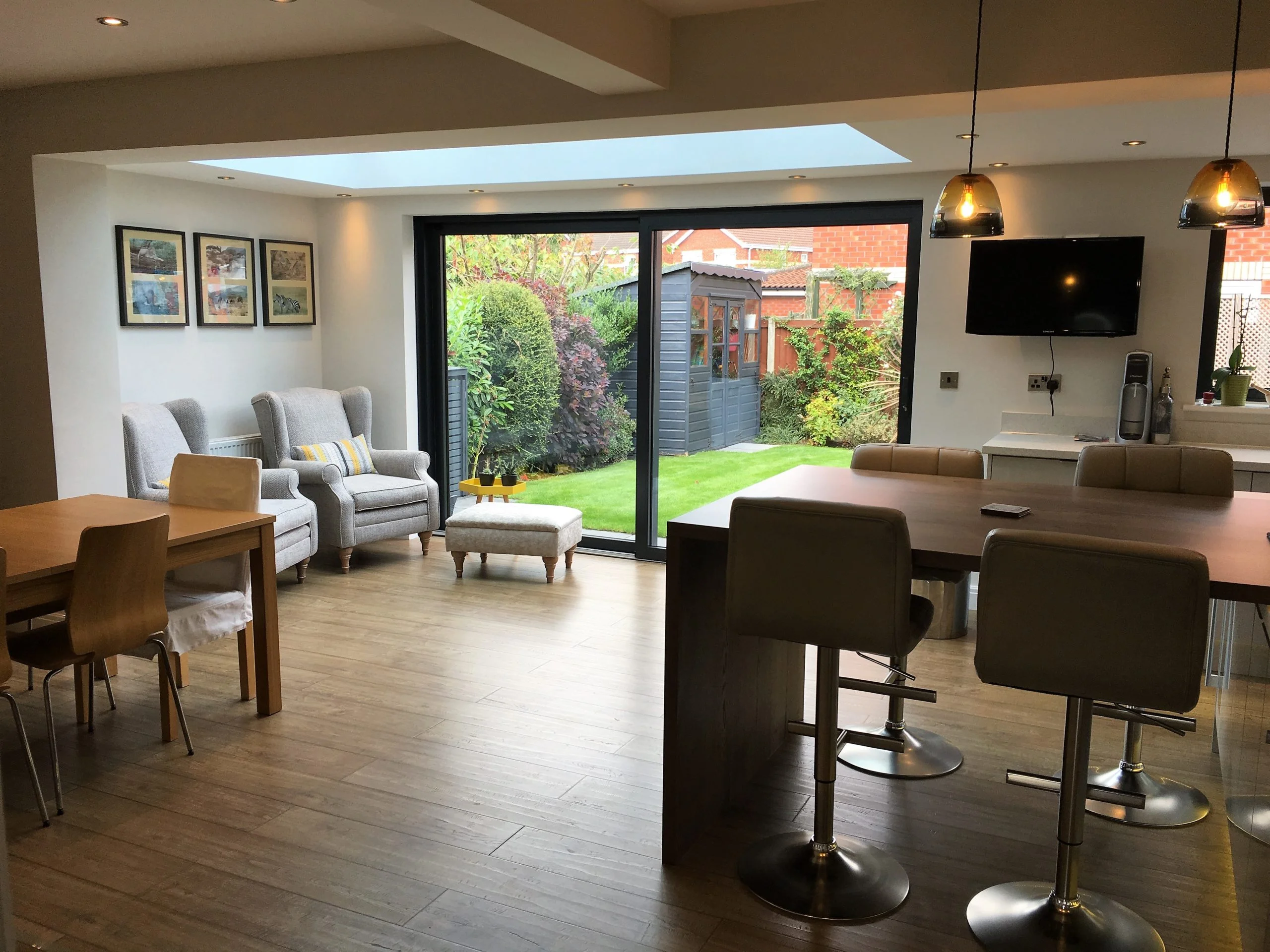 Wide angle view of modern kitchen and living area in a single storey extension